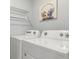 Laundry room showcasing modern washer and dryer units with a charming cat artwork at 12712 Dusty Trail Dr, Sarasota, FL 34238