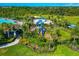 Aerial view of a community with a playground and splash pad next to mature landscaping and a grassy area at 12712 Dusty Trail Dr, Sarasota, FL 34238