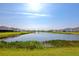 Scenic view of community pond with lush vegetation, serene water and neighboring homes at 12712 Dusty Trail Dr, Sarasota, FL 34238