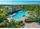 Aerial view of a community pool with palm trees and lounge chairs located in a neighborhood at 12712 Dusty Trail Dr, Sarasota, FL 34238