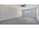 Spacious carpeted bedroom featuring a ceiling fan and window at 12728 Lateral Root Dr, Sarasota, FL 34238