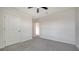 This bedroom features neutral walls, grey carpet, closet and a ceiling fan at 12728 Lateral Root Dr, Sarasota, FL 34238