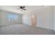 Sun-filled bedroom with a large window and neutral carpet flows into the ensuite bathroom at 12728 Lateral Root Dr, Sarasota, FL 34238