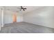 Bright bedroom features neutral carpet, ceiling fan, and a doorway to the ensuite bathroom at 12728 Lateral Root Dr, Sarasota, FL 34238