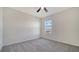 This bedroom features neutral walls, grey carpet, and a ceiling fan at 12728 Lateral Root Dr, Sarasota, FL 34238