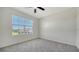 This bedroom features neutral walls, grey carpet, and a ceiling fan at 12728 Lateral Root Dr, Sarasota, FL 34238