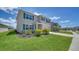 Inviting two-story home with a lush green lawn, showcasing charming blue shutters and well-maintained landscaping at 12728 Lateral Root Dr, Sarasota, FL 34238
