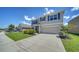 Beautiful two-story home with a well-manicured lawn, a two-car garage, and charming blue shutters at 12728 Lateral Root Dr, Sarasota, FL 34238