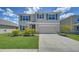 Charming two-story home with a well-manicured lawn and inviting curb appeal, featuring blue shutters at 12728 Lateral Root Dr, Sarasota, FL 34238