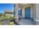 Stylish front entrance with a vibrant blue door, stone accents, and meticulously maintained landscaping at 12728 Lateral Root Dr, Sarasota, FL 34238