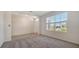 Bright living room with neutral walls, plush carpeting, tile flooring, and natural light from a window at 12728 Lateral Root Dr, Sarasota, FL 34238