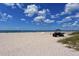 Tranquil beach scene with soft white sands, clear blue waters, and beachgoers enjoying a relaxed day by the sea at 12732 Lateral Root Dr, Sarasota, FL 34238