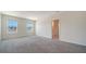 A bright bedroom with two windows and neutral carpeting, showing the doorway to the en suite bathroom at 12732 Lateral Root Dr, Sarasota, FL 34238