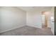 A bright bedroom featuring neutral carpeting, baseboards, light walls, and an entry door at 12732 Lateral Root Dr, Sarasota, FL 34238
