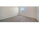 Cozy bedroom with a large window offering neighborhood views and soft gray carpet at 12732 Lateral Root Dr, Sarasota, FL 34238