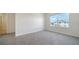 Bright bedroom with a large window offering neighborhood views and soft gray carpet at 12732 Lateral Root Dr, Sarasota, FL 34238
