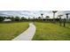 Well-maintained community dog park with lush green grass, paved walkway and seating area at 12732 Lateral Root Dr, Sarasota, FL 34238