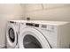 Bright laundry room with a white washer and dryer set, perfect for convenient laundry days at 12732 Lateral Root Dr, Sarasota, FL 34238