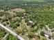Lush land with tranquil pond surrounded by beautiful mature trees from an aerial perspective on a sunny day at 13719 Seminole Trl, Wimauma, FL 33598