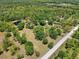 Expansive aerial view of land featuring lush greenery, a serene pond, and a quiet country road at 13719 Seminole Trl, Wimauma, FL 33598