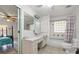 Bathroom with retro finishes, vanity, shower-tub combo and glass block window at 13719 Seminole Trl, Wimauma, FL 33598