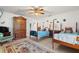 Bedroom with two beds, ceiling fan, armoire, tile floor, and fish decor at 13719 Seminole Trl, Wimauma, FL 33598