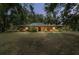 Charming single-story home with a well-manicured lawn and lush landscaping, creating a warm and inviting curb appeal at 13719 Seminole Trl, Wimauma, FL 33598