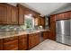 Beautiful kitchen with stainless steel refrigerator and appliances, plus cherry wood cabinetry at 13719 Seminole Trl, Wimauma, FL 33598