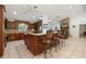 An open-concept kitchen with granite counters, wood cabinets, a center island, and bar seating at 13719 Seminole Trl, Wimauma, FL 33598