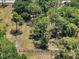 Aerial view of a fenced lot with mature trees providing privacy and shade on this lovely homesite at 13719 Seminole Trl, Wimauma, FL 33598