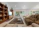 Living room view with bookshelves, a television, and comfortable sofas on tile flooring at 13719 Seminole Trl, Wimauma, FL 33598
