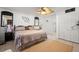 Bedroom with king-size bed, tile floors, ceiling fan, and view to bathroom at 13719 Seminole Trl, Wimauma, FL 33598