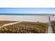 Expansive beach view featuring a wooden walkway, natural dunes, and the serene ocean horizon at 138 Pearl Ave, Sarasota, FL 34243