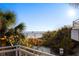 Balcony beach view with vibrant vegetation and ocean in the background, perfect spot for relaxing by the sea at 138 Pearl Ave, Sarasota, FL 34243