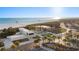 Inviting beach view featuring modern architecture, palm trees, and a glimpse of the serene ocean waters at 138 Pearl Ave, Sarasota, FL 34243