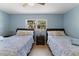 Two beds with wooden frames, serene blue color scheme, each with nightstands and bedside lamps at 138 Pearl Ave, Sarasota, FL 34243