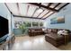 Bright living room featuring a large leather sectional, exposed beams, and expansive windows, creating a welcoming atmosphere at 138 Pearl Ave, Sarasota, FL 34243