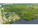 High aerial view overlooking a serene pond with a structure and roadway adjacent to a wooded area at 156 Myakka Rd, Venice, FL 34293