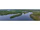 Scenic aerial shot of the dark waters of a winding river, framed by lush green islands and vegetation at 156 Myakka Rd, Venice, FL 34293