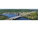 Aerial view of a highway bridge crossing a waterway lined with homes, greenery, and recreational areas at 156 Myakka Rd, Venice, FL 34293