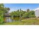 A canal view features lush foliage and a covered dock perfect for relaxing and nature viewing at 156 Myakka Rd, Venice, FL 34293