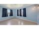 Empty bedroom with tiled floors, three windows with coverings, and light blue walls at 156 Myakka Rd, Venice, FL 34293