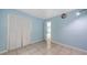 Light blue bedroom with tile flooring, neutral trim, and adjacent doorway at 156 Myakka Rd, Venice, FL 34293