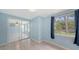 Light blue bedroom featuring sliding glass closet doors, an adjacent window with curtains, and tile flooring at 156 Myakka Rd, Venice, FL 34293