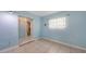 Light blue bedroom with tile flooring, adjacent window, and en suite bathroom at 156 Myakka Rd, Venice, FL 34293