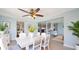 Bright dining room with a white table set, modern ceiling fan, and views into the updated kitchen at 156 Myakka Rd, Venice, FL 34293