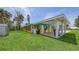 Exterior side view featuring colorful tropical painting, a large yard and covered parking at 156 Myakka Rd, Venice, FL 34293