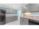 Updated kitchen featuring granite countertops, gray cabinetry, and stainless steel appliances at 156 Myakka Rd, Venice, FL 34293