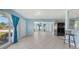 Bright living room with tile floors and large windows with blue curtains at 156 Myakka Rd, Venice, FL 34293