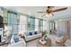 Sunlit living room with stylish seating, neutral color palette, and access to an additional room through glass doors at 156 Myakka Rd, Venice, FL 34293